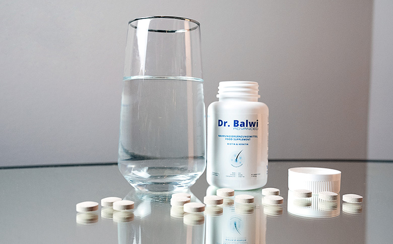 Dr Balwi Biotin und Keratin Tabletten neben einem Glas Wasser